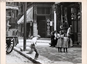 A Boy Runs onto the Sidewalk Near Two Girls at the Corner of Broadway and Cerre